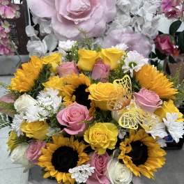 Bouquet of yellow sunflowers, pink and white roses, and white daisies