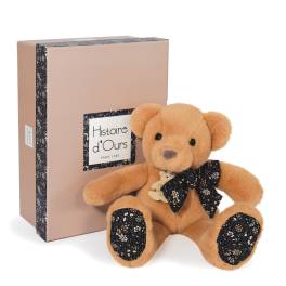 Plush teddy bear with a ribbon bow beside a pink gift box