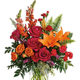 Mixed bouquet of roses and lilies in a clear glass vase