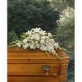 White floral spray on a wooden casket