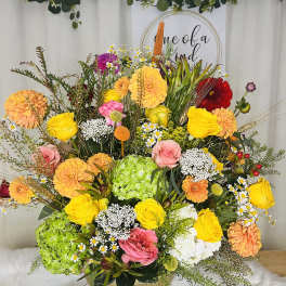 Colorful mixed flower arrangement in a gold bowl vase