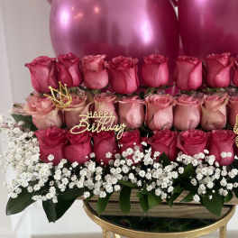 Tiered pink rose arrangement with birthday topper and balloons