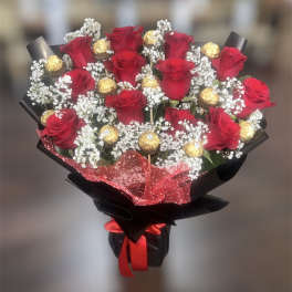 Bouquet of red roses with gold-wrapped chocolates and white baby's breath