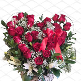 Red rose bouquet with white filler flowers in a wicker basket