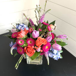 Colorful mixed bouquet in a square glass vase