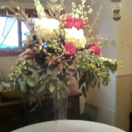 Tall floral arrangement with red and white roses in a clear vase