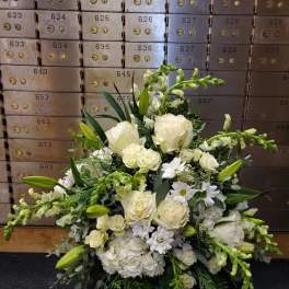 White floral arrangement with roses, lilies, and daisies