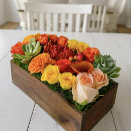 Colorful floral arrangement in a wooden box with roses and succulents