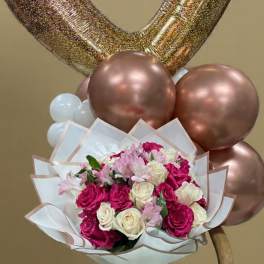 Heart-shaped balloons above a bouquet of pink and white roses