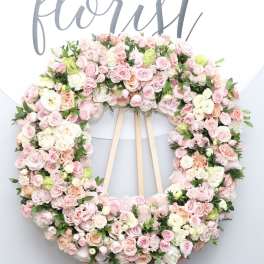 Large pastel floral wreath on a wooden easel