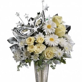 White and pale yellow flowers in a tall silver vase with star picks