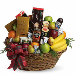 Gift basket with fruit, chocolates, and sausage in a wicker basket