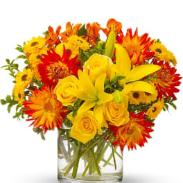 Yellow and orange mixed bouquet in a clear glass vase