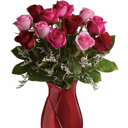Bouquet of pink and red roses in a red glass vase