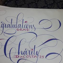 Decorative calligraphy reading "Congratulations Grad" and a name on white paper