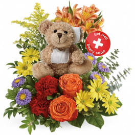 Teddy bear surrounded by colorful flowers with a get well soon sign