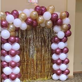 Balloon arch in burgundy, white, and gold with a metallic fringe backdrop