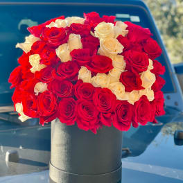 Round bouquet of red and white roses in a black box