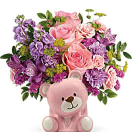 Pink teddy bear vase filled with pink and purple flowers