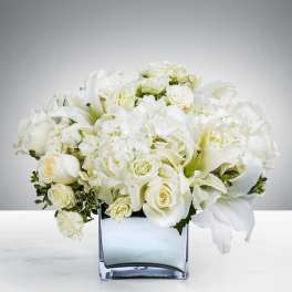 White floral arrangement in a square glass vase