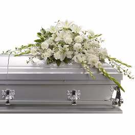 White floral casket spray on a silver casket