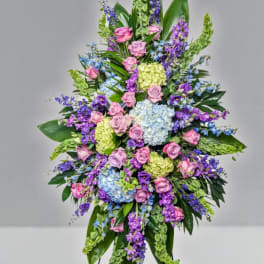 Large standing spray of pink, purple, blue, and green flowers