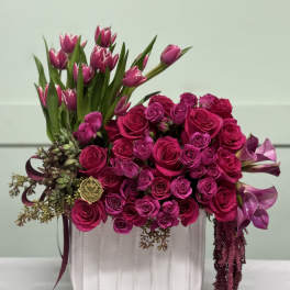 Pink roses and tulips arranged in a white vase