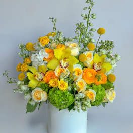 Yellow and white floral arrangement in a white vase