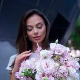 Woman holding a pink and white bouquet of mixed flowers