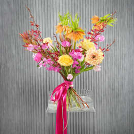 Colorful bouquet of pink, yellow, and orange flowers tied with a ribbon