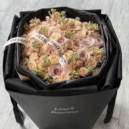 Bouquet of blush and peach roses in a black gift box