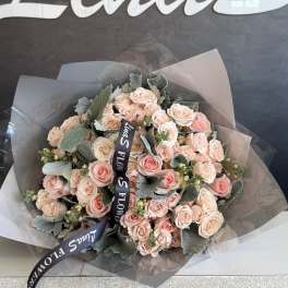 Bouquet of pale pink roses wrapped in translucent paper