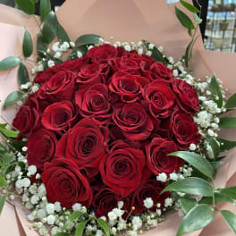 Bouquet of red roses with white baby's breath and green foliage