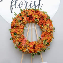 Large orange floral wreath on a wooden easel