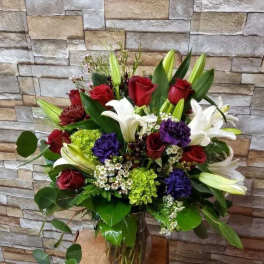 Bouquet of red roses and white lilies in a glass vase