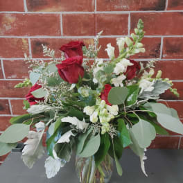 Red roses and white snapdragons in a glass vase
