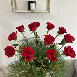 Arrangement of red roses with airy greenery in a vase