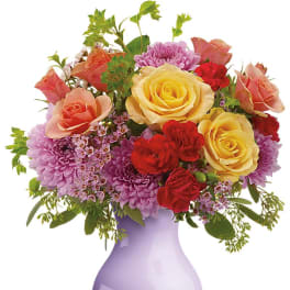 Mixed bouquet of roses and purple chrysanthemums in a lavender vase