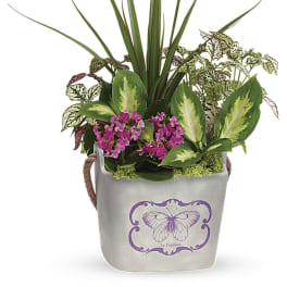 Mixed potted plants in a gray container with pink flowers