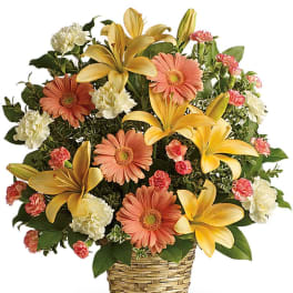 Basket arrangement of yellow lilies, peach gerberas, and white carnations