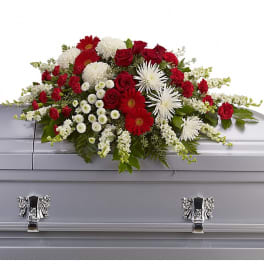 Red and white floral spray on a gray casket
