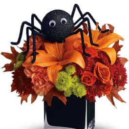Halloween bouquet with a black spider topper in a square vase