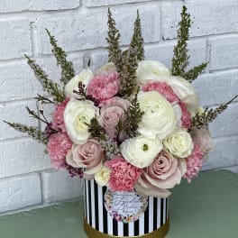 Pink and white bouquet in a striped round box
