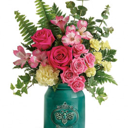Pink roses and alstroemeria in a teal vase with mixed greenery