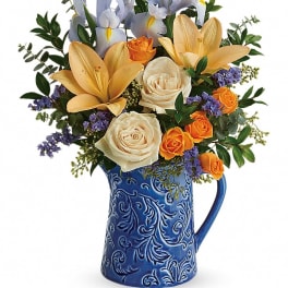 Bouquet of roses and irises in a blue ceramic pitcher