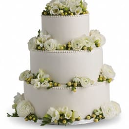 Four-tier white wedding cake with white floral decorations