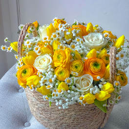 Yellow and white flower arrangement in a woven basket