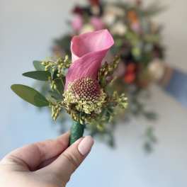 Pink calla lily boutonniere with small green accents