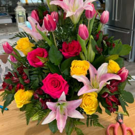 Pink lilies, roses, tulips, and yellow roses in a large bouquet
