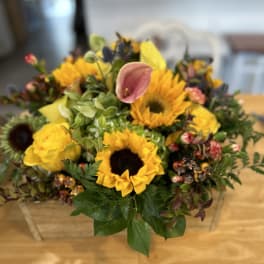 Sunflower and pink calla lily arrangement in a clear glass vase